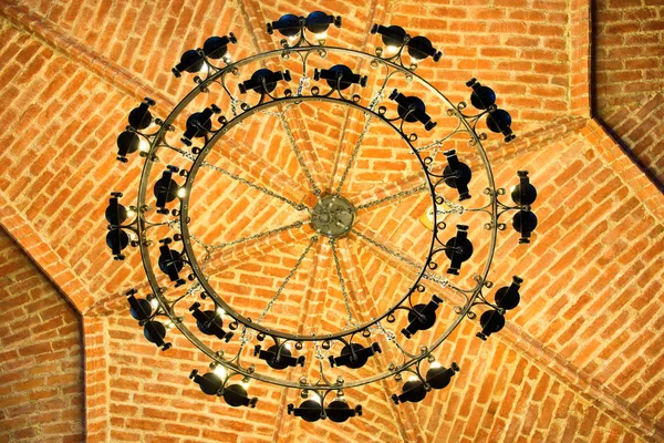 Люстра на кирпичном потолке в замке — стоковое фото