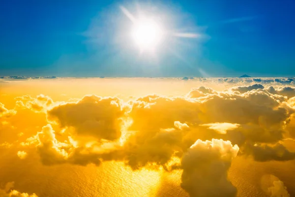 Blick aus dem Flugzeug auf Wolken, Meer und strahlende Sonne — Stockfoto