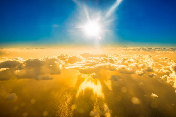 Vliegtuig uitzicht op wolken, de Oceaan en de stralende zon — Stockfoto