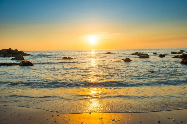 海岸に砂浜 黄金の太陽と石と美しいカラフルな夕日の風景 — ストック写真