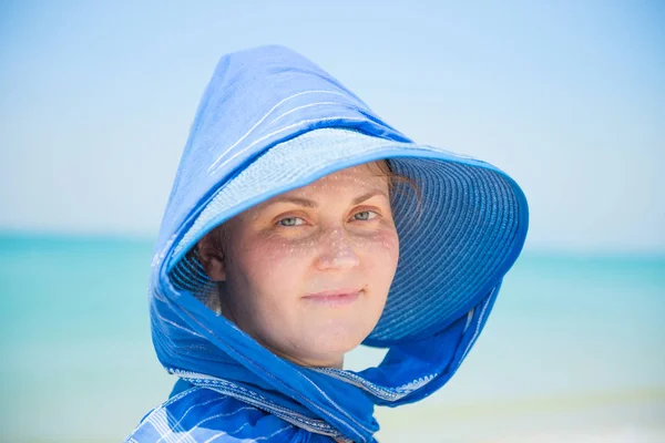 Woman in hat on blue water background — Stock Photo, Image