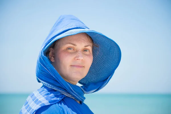 Woman in hat on blue water background — Stock Photo, Image