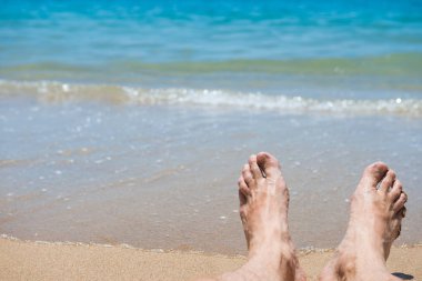 Kumsalda çıplak insan ayakları