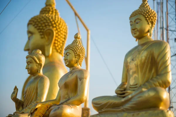 Zlatavé sochy Buddhy na modrém nebeském pozadí — Stock fotografie