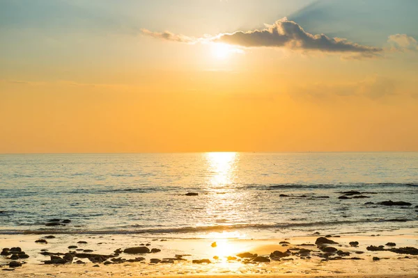 Západ slunce s pláží, sluncem a kameny na mořském pobřeží — Stock fotografie