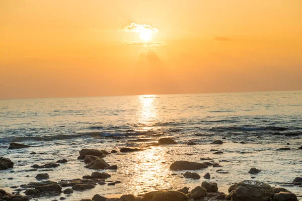 Západ slunce s pláží, sluncem a kameny na mořském pobřeží — Stock fotografie