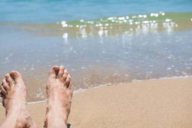 Kumsalda çıplak insan ayakları