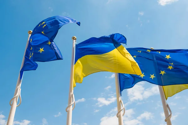 Fahnenmasten mit europäischer Union und ukrainischen Flaggen auf blauem Himmel — Stockfoto