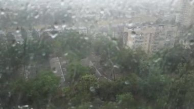 Şehirde şiddetli fırtına yağmuru. Yağmurlu sokak ve düşen su damlaları. 4k klip