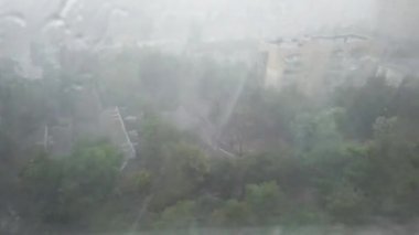 Şehirde şiddetli fırtına yağmuru. Yağmurlu sokak ve düşen su damlaları. 4k klip