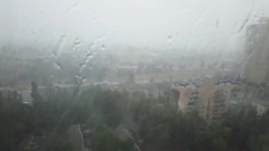 Şehirde şiddetli fırtına yağmuru. Yağmurlu sokak ve düşen su damlaları. 4k klip