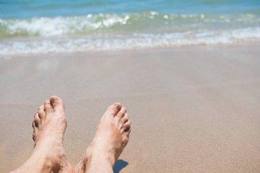 Kumsalda çıplak insan ayakları