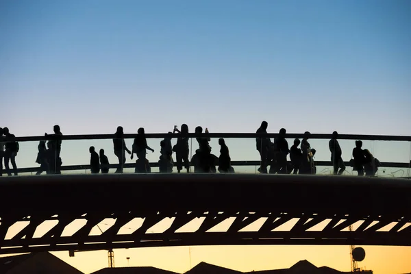 Silueta de personas caminando en el puente — Foto de Stock
