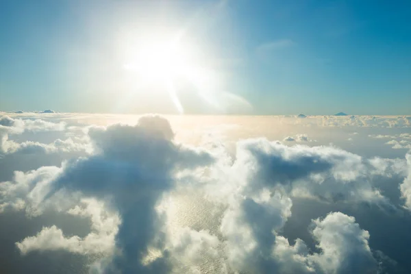 Avião vista de nuvens, oceano e sol brilhante — Fotografia de Stock