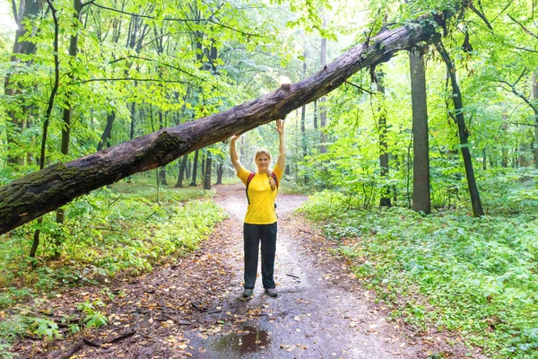 Mulher feliz com árvore caída na floresta — Fotografia de Stock