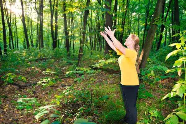 Lycklig kvinna outstretching händer till sön — Stockfoto