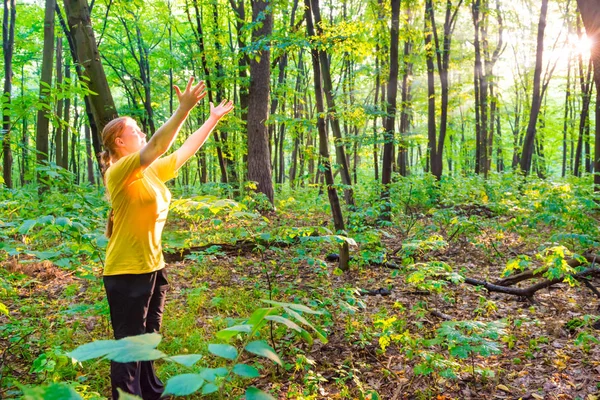 Gelukkige vrouw die de handen naar de zon uitrekken — Stockfoto