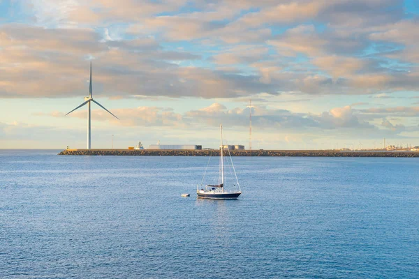 Пейзаж с бухтой, волнорезом, ветряной мельницей и яхтой — стоковое фото