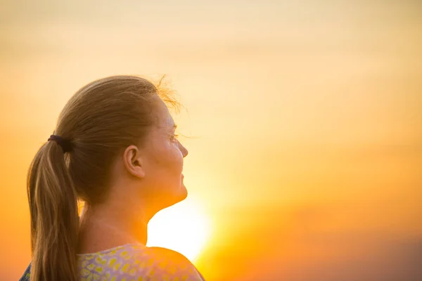 Žena hledající krásný západ slunce — Stock fotografie