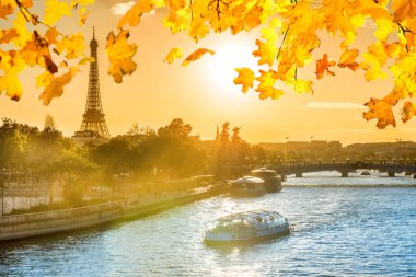Paris 'te Eyfel Kulesi ve Seine nehri ile güzel bir gün batımı turuncu sonbahar yapraklarıyla, Paris Fransa