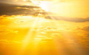 Güneş ışığı ve sarı bulutlu gün batımı turuncu gökyüzü