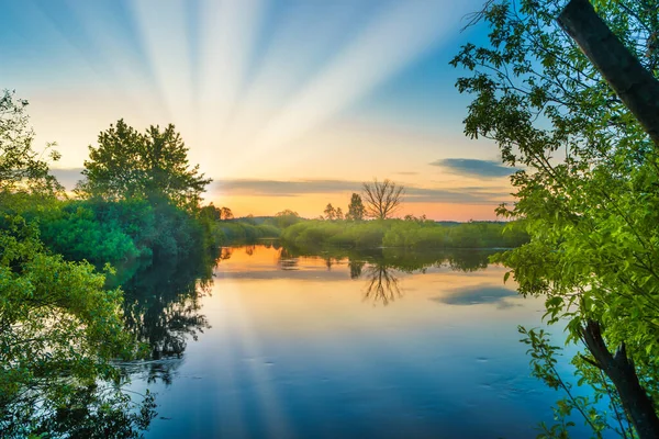 Lake water sunset and sun rays on nature landscape with sunset sky