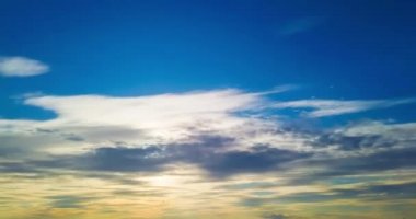 Gün batımı gökyüzü ve mavi arka planda hareket eden güneşli bulutlar. Zaman Ayarı 4K şarjörü