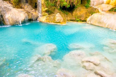 Vahşi orman ormanlarındaki zümrüt mavisi gölde taşlarla çağlayan kayaların tropik manzarası. Erawan Ulusal Parkı, Kanchanaburi, Tayland