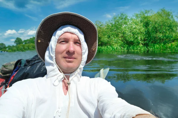 夏季河运中 身穿白色连帽衫 头戴帽子的男人在皮划艇上自拍照片 — 图库照片