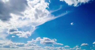 Beyaz bulutların, güneş ışığıyla mavi gökyüzünde hareket etmesinin zamanaşımı. Zaman Ayarı 4K şarjörü