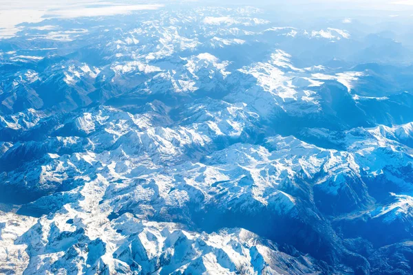 白い雪に覆われた青い山の飛行機のビュー 自然の背景として使用できます — ストック写真