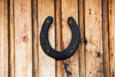 Ahşap duvarda eski kırsal at nalı. Şans için paslı at nalı.