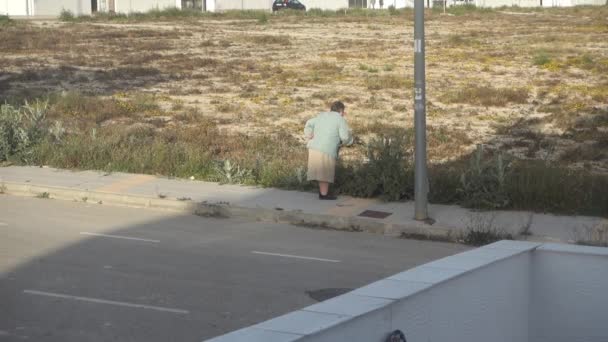 Mujer mata malezas con palo — Vídeos de Stock