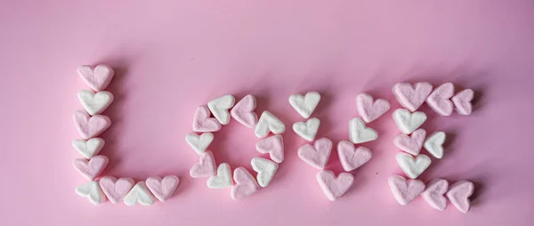 ピンクの背景の上にハート型のマシュマロで作られた バレンタイン コンセプト ワードと愛 — ストック写真