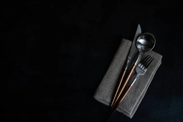 现代金属餐具和餐巾设置与迷迭香在黑暗的背景与复制空间 — 图库照片