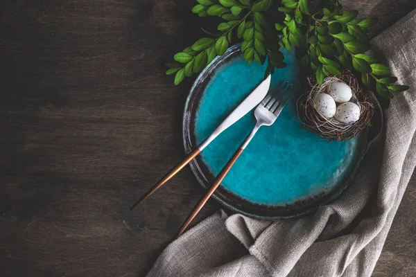 stock image Spring table setting for Easter holiday dinner with boxwood and colored eggs on wooden table with copy space