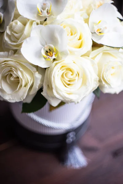 礼品盒充满了美丽的白玫瑰和兰花在黑暗的木制背景与复制空间 — 图库照片