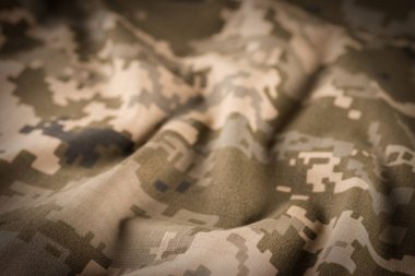 Kumaş doku arka plan kamuflaj. Yumuşak seçici odak ve sığ derinlik-in tarla