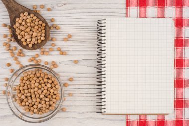 Bir kaşık ve bir eski ahşap masa üstünde not etmek ile bir cam kapta nohut. Üstten Görünüm.
