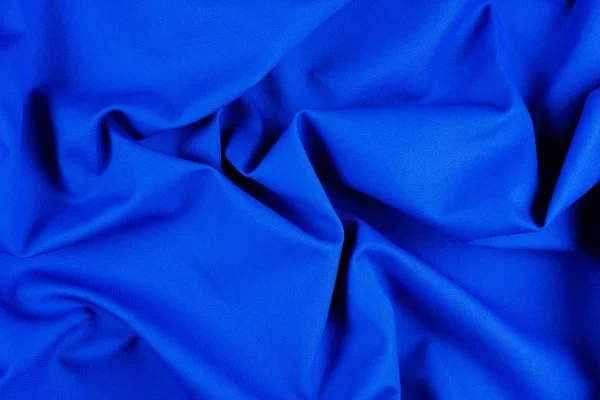 Φωτεινή μπλε υφασμάτινη υφή με πτυχώσεις. — Φωτογραφία Αρχείου