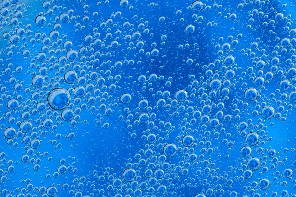 Grandes burbujas de oxígeno hermosas bajo el agua sobre un fondo azul macro. — Foto de Stock