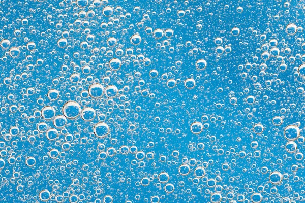 Grandes burbujas de oxígeno hermosas bajo el agua sobre un fondo azul macro. —  Fotos de Stock