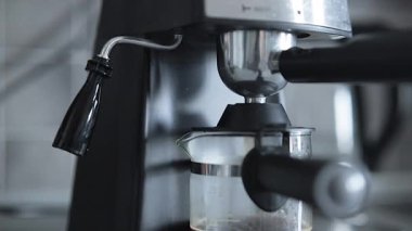 Barista kahve yapar. Kahve makinesinden dökülen espressonun yakın çekimi.