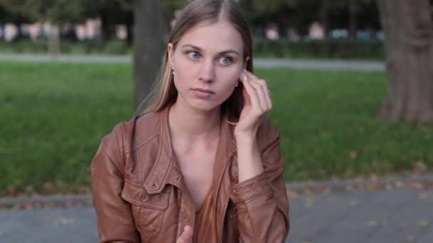 Close up portrait of a young girl listening to music through wireless earphones — Stock Video