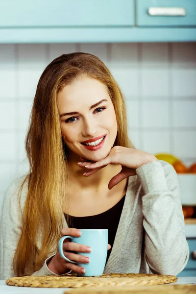 Mulher branca bonita está sentada à mesa com xícara de café — Fotografia de Stock