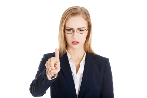 Confused business woman in eyeglasses is looking at her finger. — Stock Photo, Image