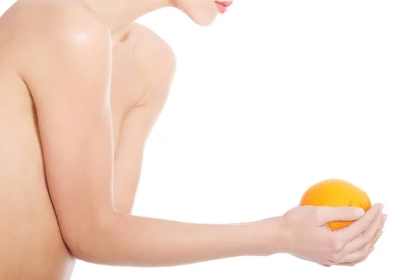 Hermosa mujer en topless sosteniendo una naranja . — Foto de Stock