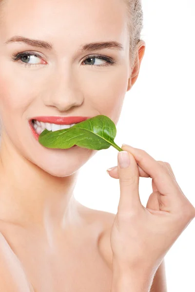 Beautiful caucasian woman eating fresh green leaf. — Stock Photo, Image