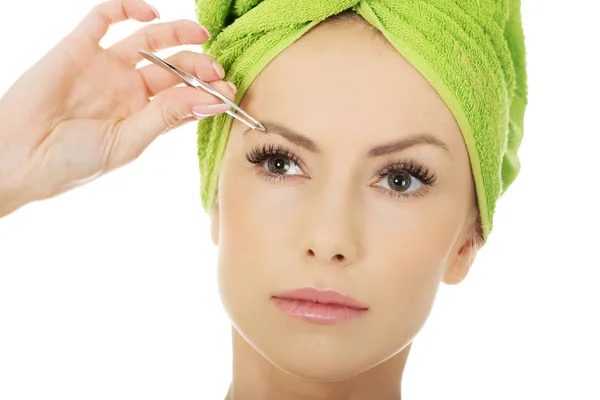 Beautiful woman plucking her eyebrow. — Stock Photo, Image