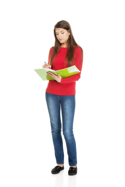Jovem estudante mulher escrevendo em sua nota . — Fotografia de Stock